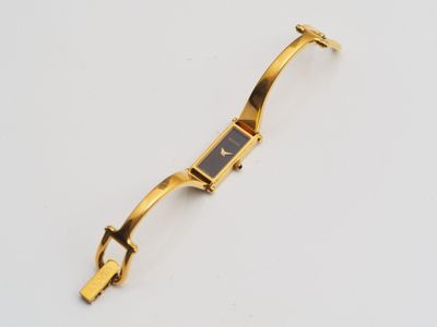 a close up of a gold watch on a white surface