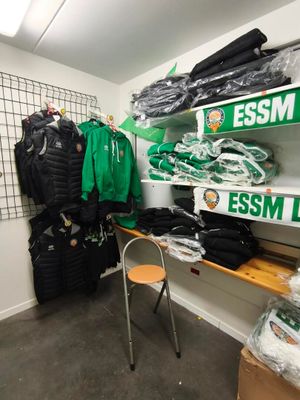 une pièce où les étagères sont remplies de vêtements et de sacs