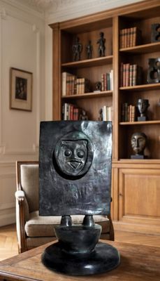 a black sculpture on a wooden table in a living room