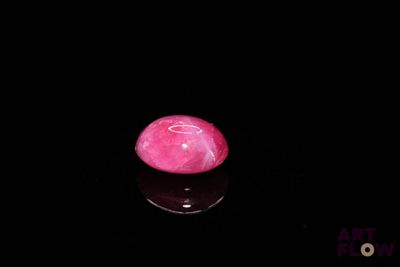 a picture of a pink stone on a black surface