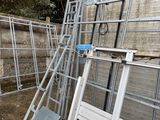 a pile of ladders that are leaning against a wall