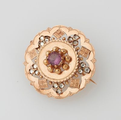 an image of a gold and amethorate broochle on a white surface