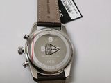 the watch is sitting on a white surface with a tag on it