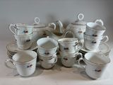 a lot of cups and saucers sitting on a table