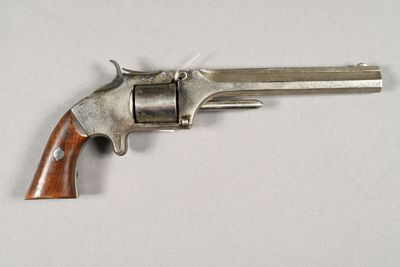gros plan d'un revolver sur une surface blanche