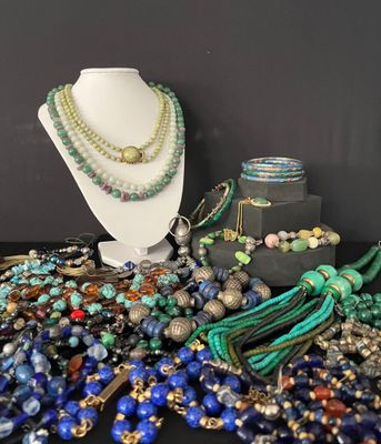 many different colored beads and necklaces displayed on a table