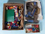 une boîte remplie de Lego et d'autres jouets posée sur une surface bleue
