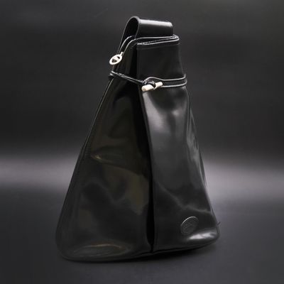 sac à main en cuir noir sur fond noir, muni d'un fermoir argenté