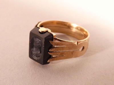 an image of a gold ring with a black stone
