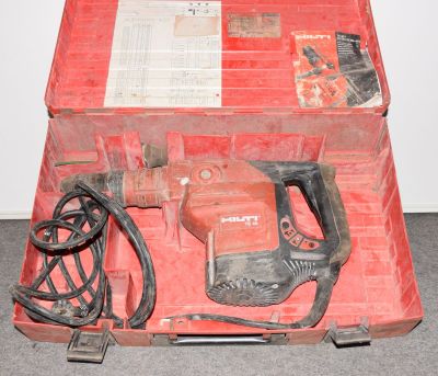 une boîte rouge contenant des outils, posée sur le sol