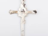 a white cross on a white wall with a black cat on it