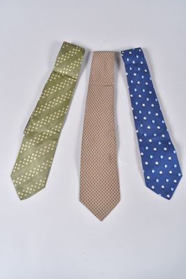 four different colored ties are lined up on a white surface