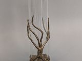 a glass vase with a metal decoration on it