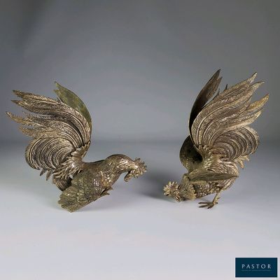 paire d'oiseaux anciens en métal argenté, les ailes déployées, sur fond blanc