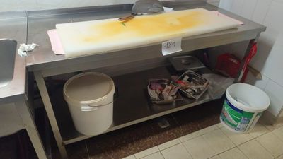 a picture of a dirty kitchen with a sink and a trash can