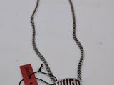 the necklace is silver with a red tag on it