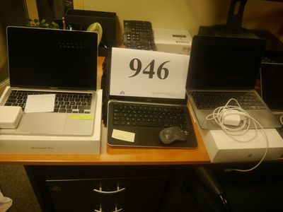 trois ordinateurs portables posés sur un bureau, avec une étiquette de prix dessus