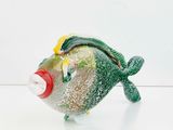 a glass fish that is sitting on a white surface