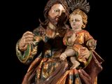 statue of a man holding a child with a crown on his head