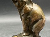 statue of an elephant on a marble base with a black background