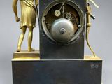 a statue of a man holding a clock with a bird on it
