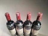 four bottles of wine are lined up in a row on a table