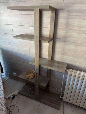 une étagère en bois sur laquelle est posé un panier, à côté d'un radiateur