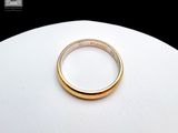 a gold ring on a white plate on a table