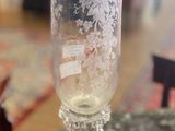 un vase en verre posé sur une table, à côté d'une horloge