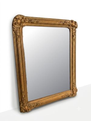 a gold framed mirror on the wall next to a white wall