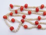 pearl and coral bead necklace on a white background
