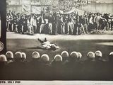 a black and white photo of a man laying on the ground in front of a crowd