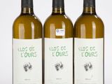 trois bouteilles de vin posées les unes à côté des autres sur une surface blanche