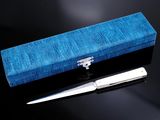une boîte bleue avec une paire de ciseaux à côté