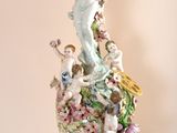 a statue of a woman on top of a vase on a table
