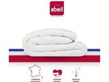 un gros plan d'un lit recouvert d'une couette blanche