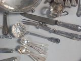 a lot of silver spoons and spoons on the table