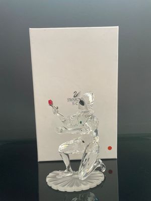 une figurine en verre posée sur une table, à côté d'une carte
