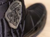 a close up of a black boot with a badge on it