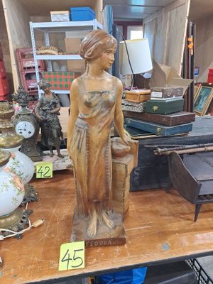 une statue représentant une femme, posée sur une table