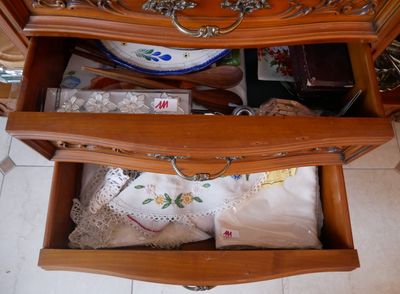 une commode en bois dont un tiroir est rempli d'objets