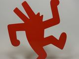 statue of a dancing man on a red base on a white background