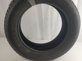 a close up of a tire on a white surface with a curtain in the background