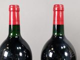 two bottles of wine sitting next to each other on a table