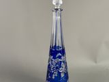 un vase en verre bleu et transparent orné d'un motif floral