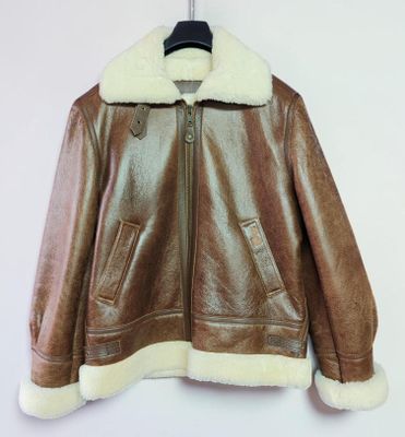 veste en cuir marron avec col et poignets en fourrure blanche, suspendue à un cintre