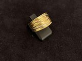 a close up of a gold ring on a black surface