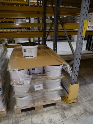 boxes of paint are stacked on a pallet in a warehouse