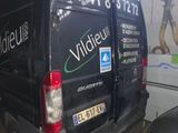 a van that is parked in a garage with other cars