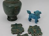 a small green vase with a dog figurine next to it